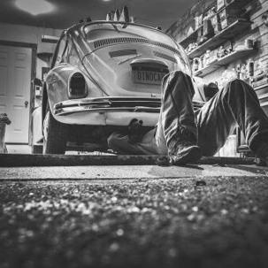 person working underside Volkswagen Beetle