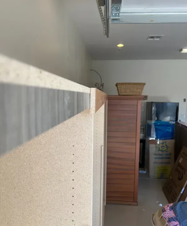 Close-up of cabinet edge with woodgrain and laminate trim
